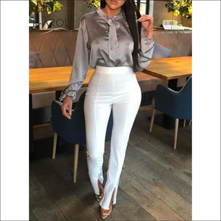 Elegant woman's outfit with gray blouse and white pants in restaurant setting